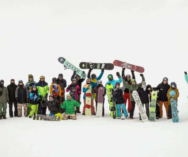 Lidi sedí na zelených schodech s notebooky